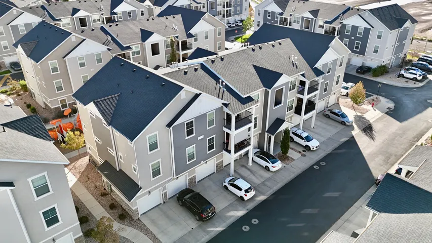 Multi-story residential buildings featuring gabled roofs, balconies, and attached garages