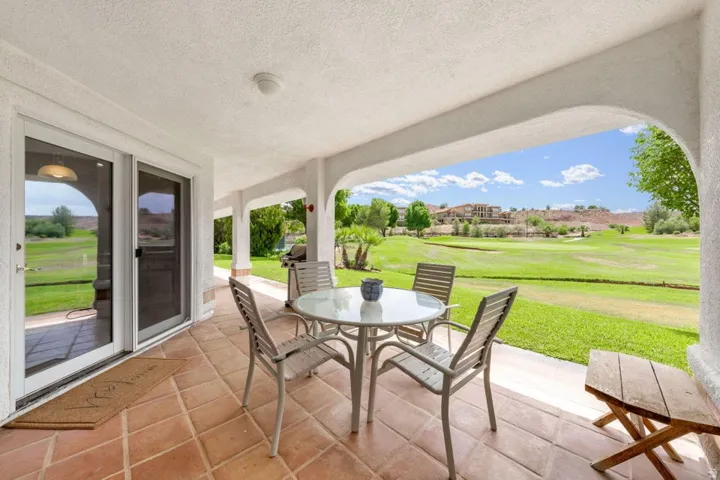 Covered patio with terracotta tile flooring, archways, and sliding glass doors