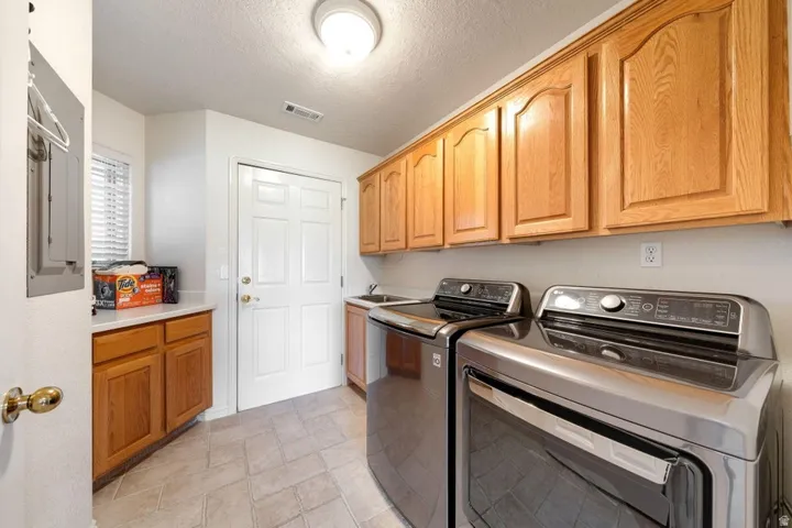 Built-in cabinetry with wood-finish fronts, light-toned countertop, and an integrated sink