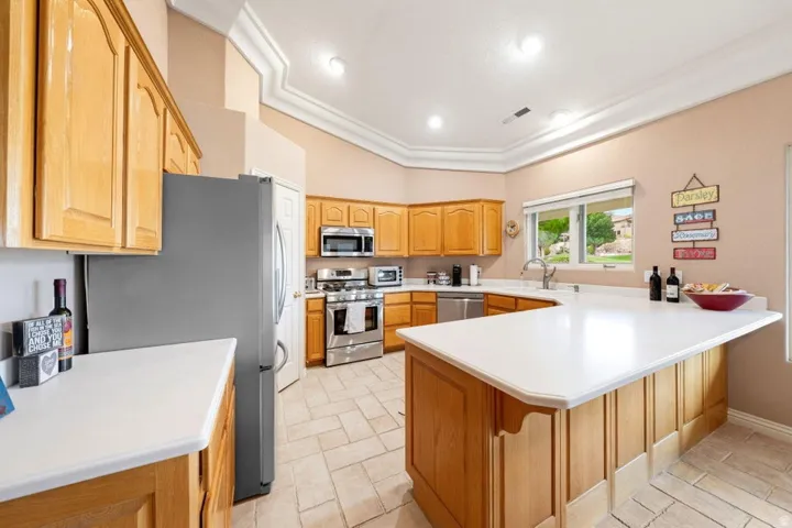Kitchen featuring wood cabinetry, stainless steel appliances, white countertops, recessed lighting, and tile flooring