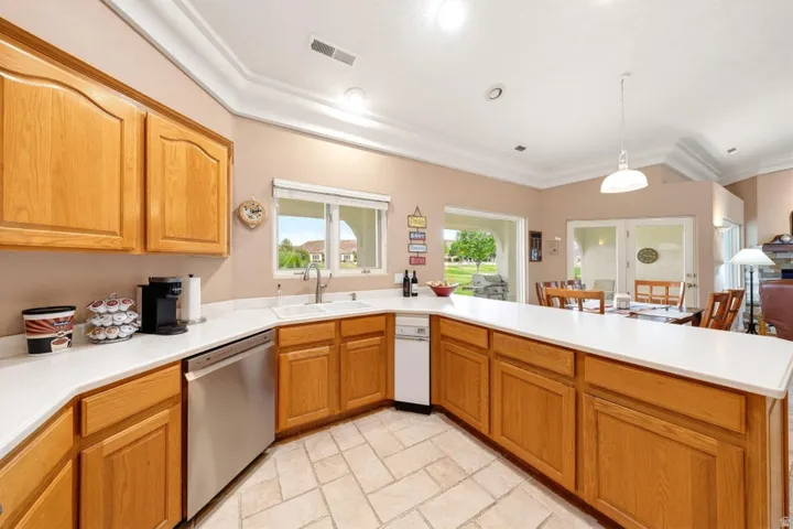 Kitchen featuring wood cabinetry, white countertops, tile flooring, and stainless steel appliances