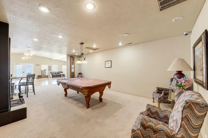 Spacious room featuring recessed lighting, a vaulted ceiling, and an expansive carpeted floor