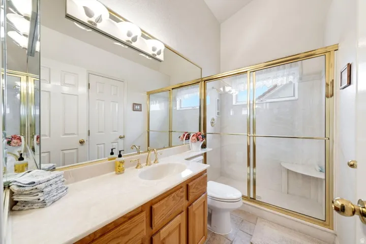 Built-in vanity with wood cabinetry, integrated sink, and gold-finish fixtures