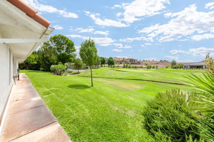 Expansive green space with mature trees, established landscaping, and a golf course beyond