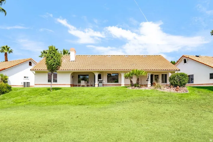 Expansive green lawn with a stucco exterior and terracotta tile roof