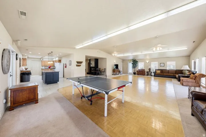 Expansive open-concept room featuring a kitchen with a central island, recessed lighting, and tile flooring