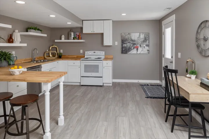 Full kitchen featuring white cabinetry, wood-finish countertops, and stainless steel sink