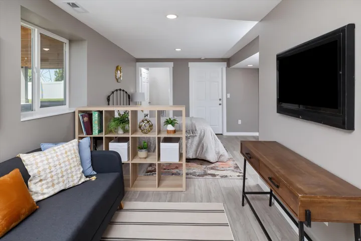Light wood-finish flooring, a white window, recessed lighting, and a white interior door