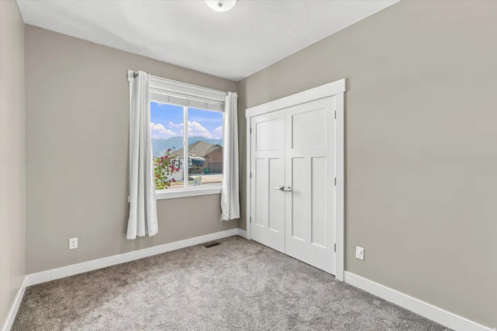 Double-panel interior doors, light gray wall paint, white trim, and gray carpet