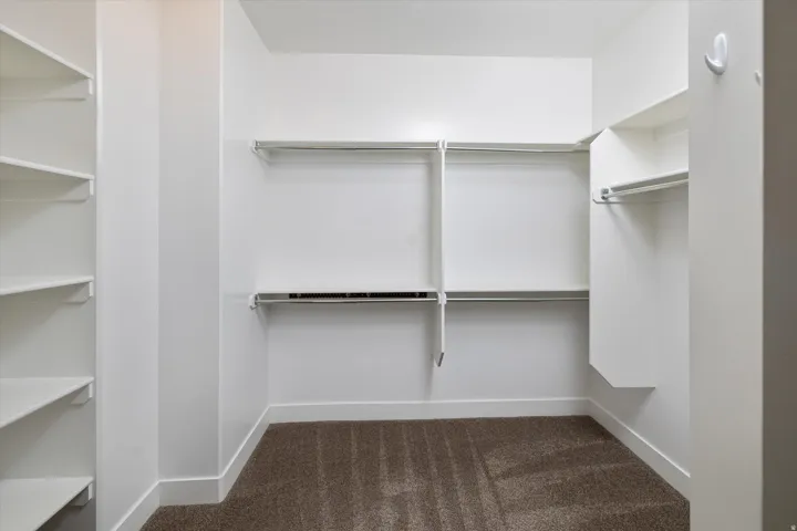 Integrated shelving, multiple hanging rods, corner shelving, and carpeted flooring