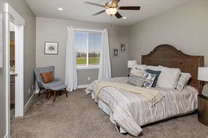Neutral wall tones, recessed lighting, ceiling fan with light fixture, window with blinds, and durable carpet flooring