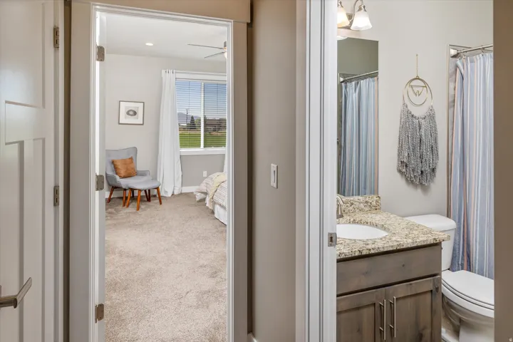 Bedroom with carpeted flooring and window with blinds