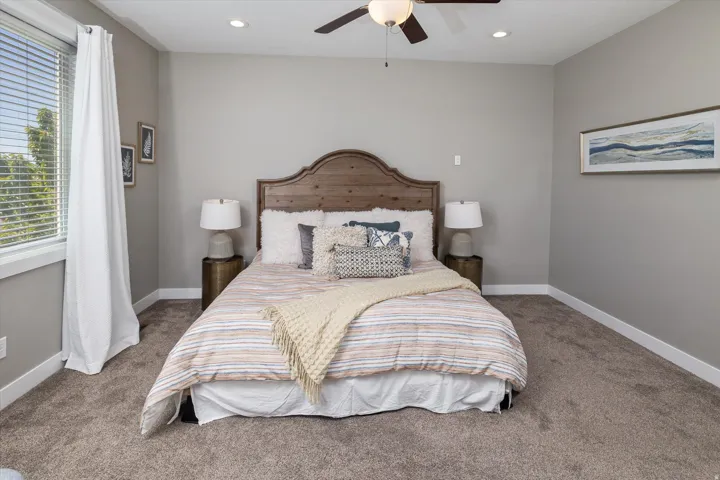 Plush carpeting, recessed lighting, and a ceiling fan create a comfortable atmosphere