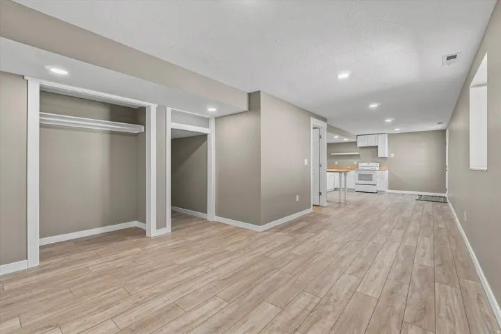 Spacious open room with wood-finish flooring, recessed lighting, and a neutral color palette