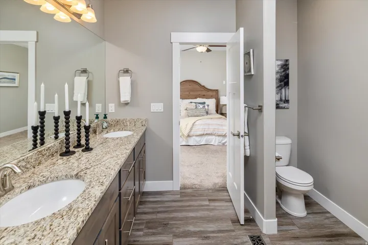 Dual vanity with undermount sinks, granite-style countertop, and wood-finish cabinetry