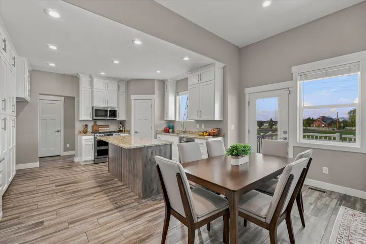 Kitchen featuring white cabinetry, stone countertops, wood-finish flooring, recessed lighting, and a center island