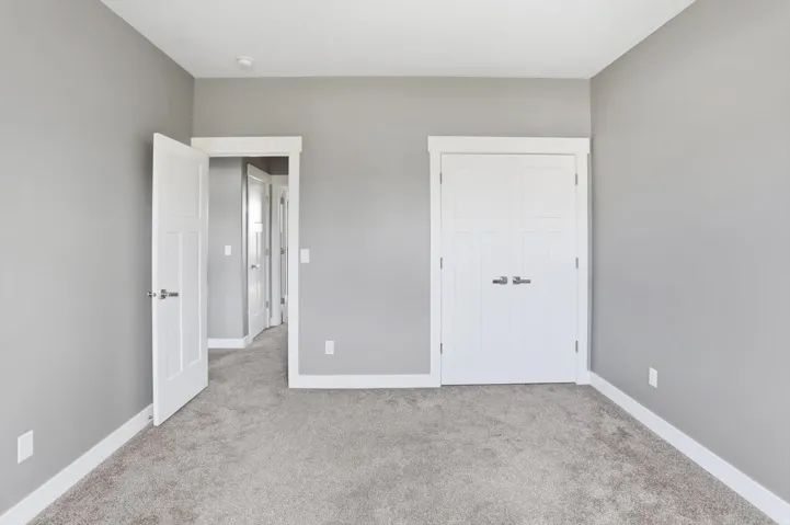 Plush carpeting, neutral wall color, white trim, recessed lighting, and panel interior doors