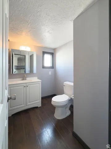 White vanity with a single basin sink, chrome faucet, and mirrored medicine cabinet