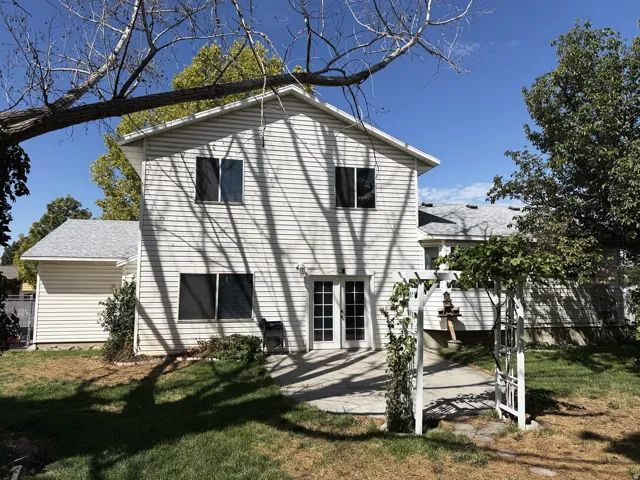 Rear exterior featuring white vinyl siding, double-pane windows, and a patio with French doors