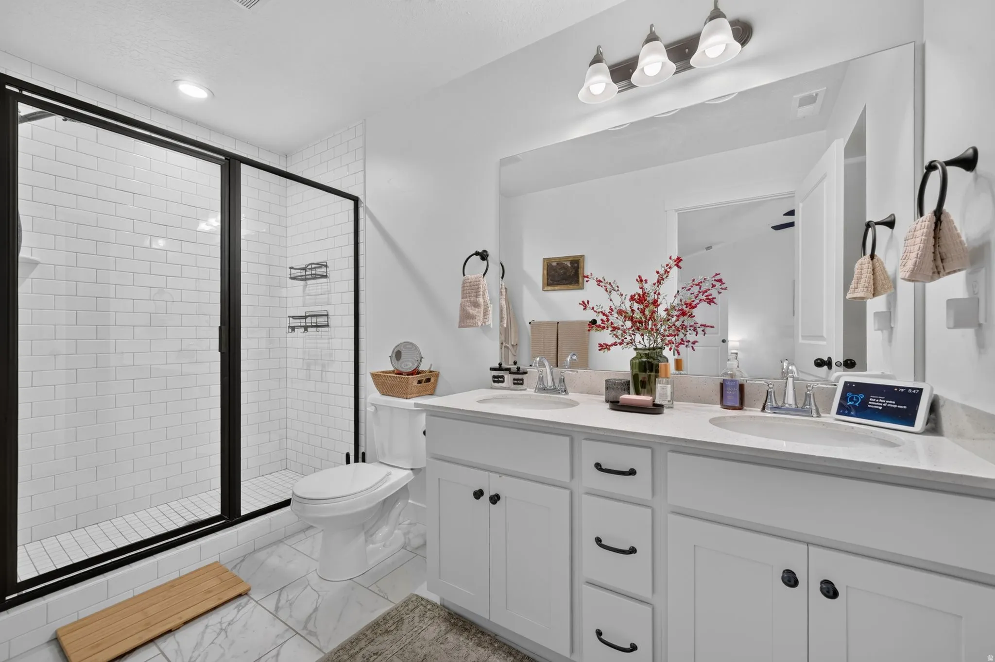 Dual vanity with undermount sinks, white cabinetry, and a full-width mirror