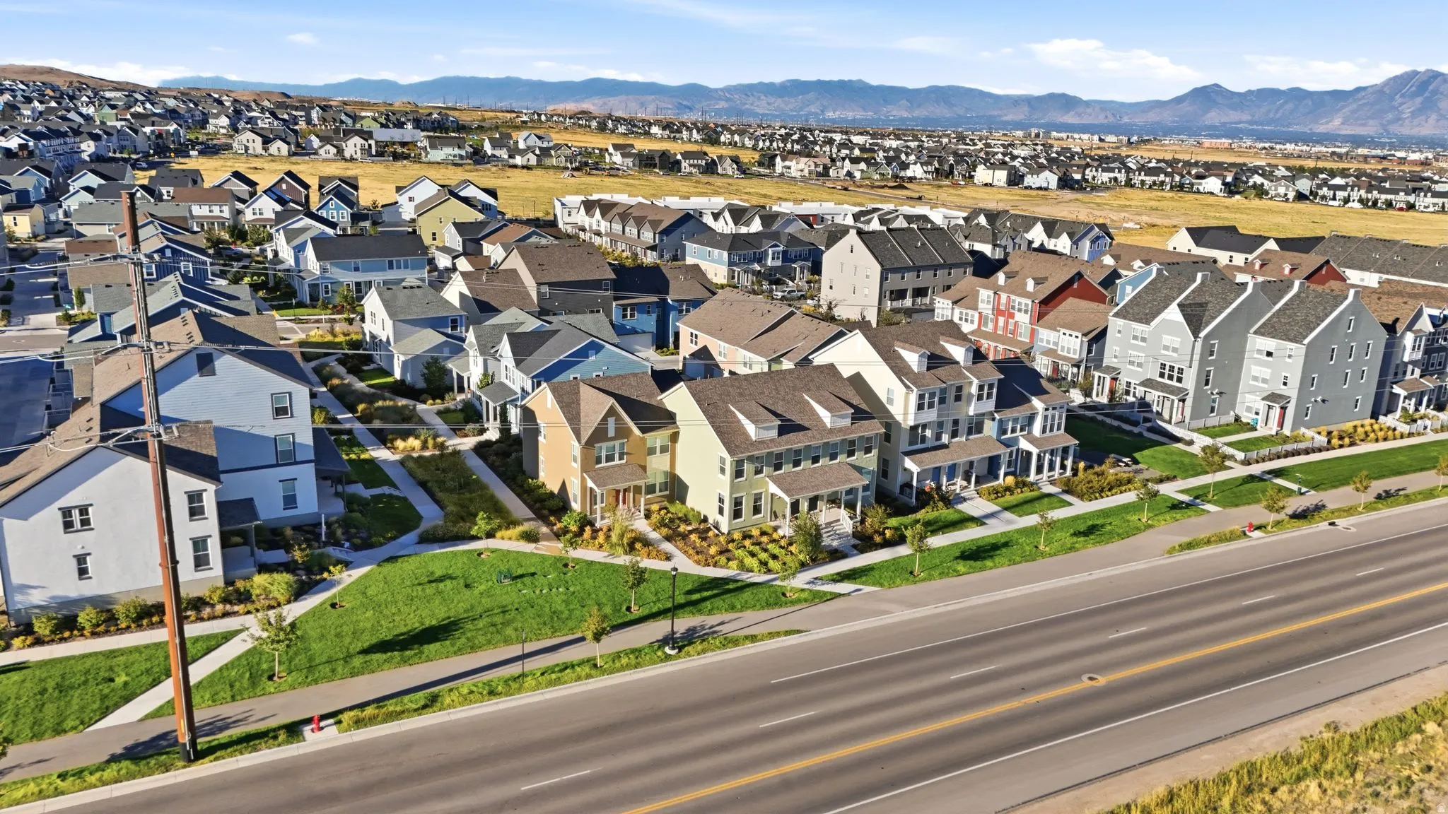 Residential neighborhood with varied architectural styles, green spaces, and paved roadways