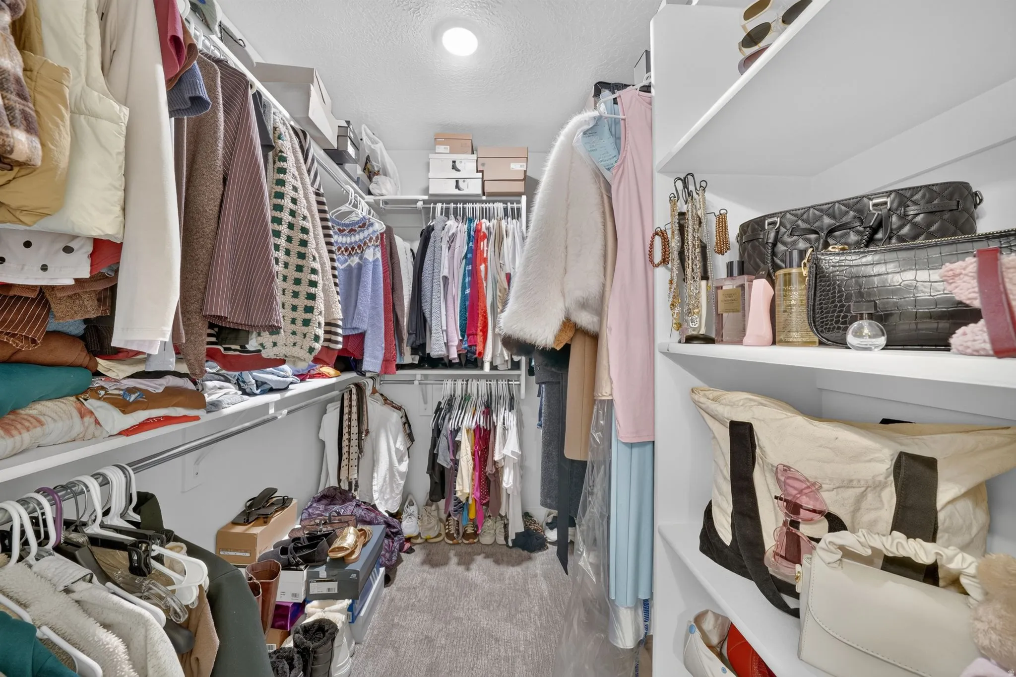 Walk-in closet featuring extensive built-in shelving and hanging rods