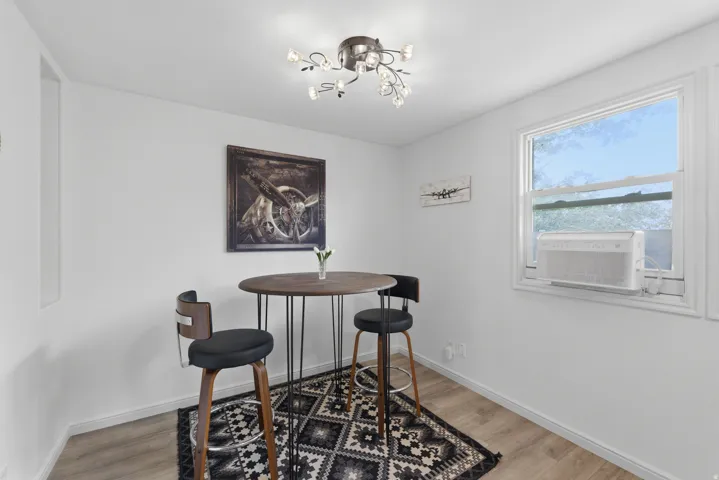 Recessed wall niche, contemporary ceiling light fixture, wood-finish flooring, and a window