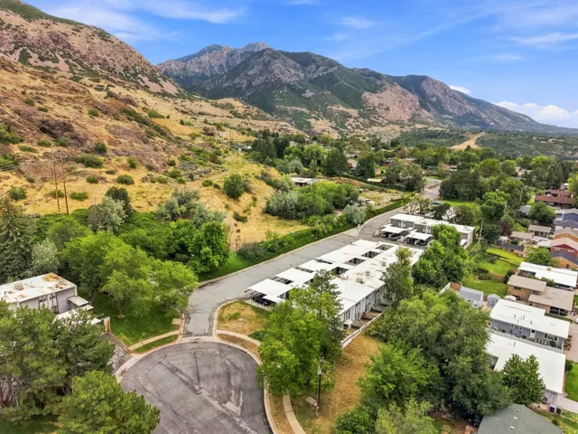 Mountainous terrain with lush green trees, cul-de-sac, and residential structures