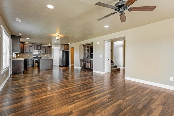 Kitchen featuring dark wood-finish cabinetry, stainless steel appliances, and a tiled backsplash