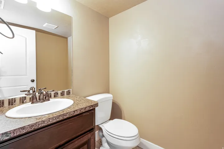 Vanity with a solid surface countertop, undermount sink, and bronze-finish faucet