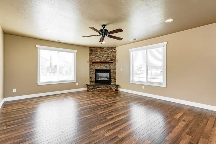 Corner fireplace featuring a stone surround and wood mantel
