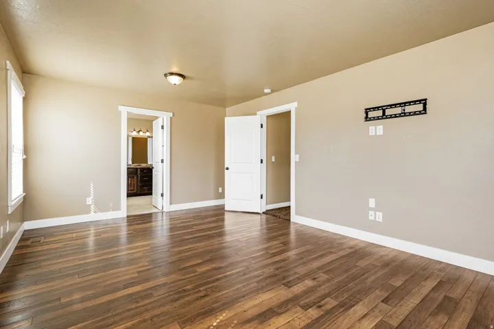 Wood-finish flooring, neutral wall tones, white trim, and a ceiling-mounted light fixture