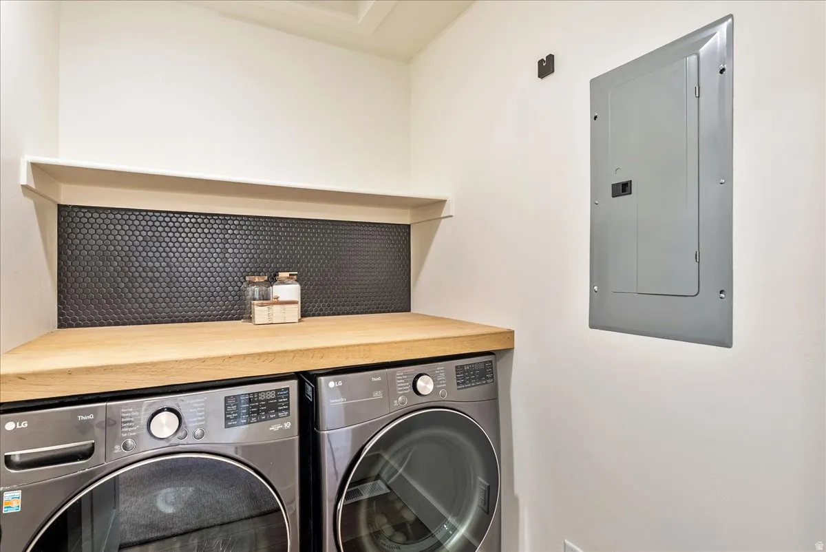 Wood-finish countertop with a black penny tile backsplash and white wall shelf