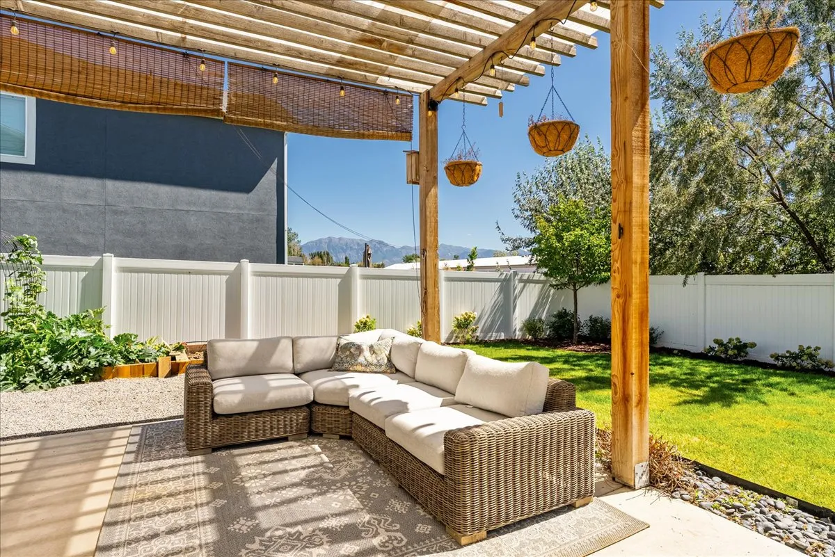 Covered patio with a wood pergola, concrete patio surface, and a slatted privacy screen