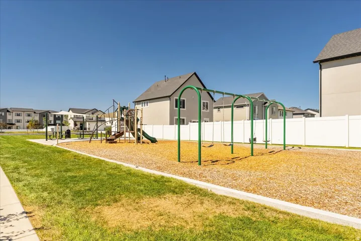 Community playground featuring a swing set, slide, and climbing structures on a wood chip surface