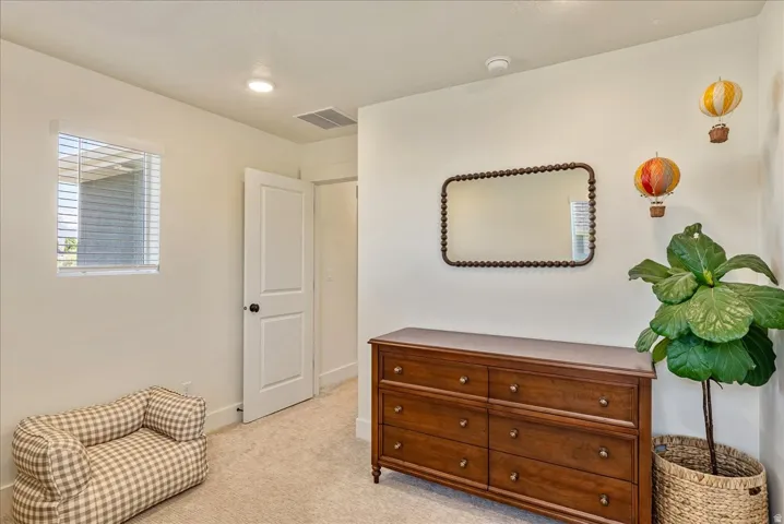 Light-colored wall finishes with recessed lighting and carpeted flooring