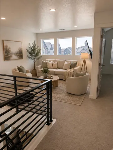 Upper-level living space featuring recessed lighting, three large windows, and carpeted flooring. Virtually staged.