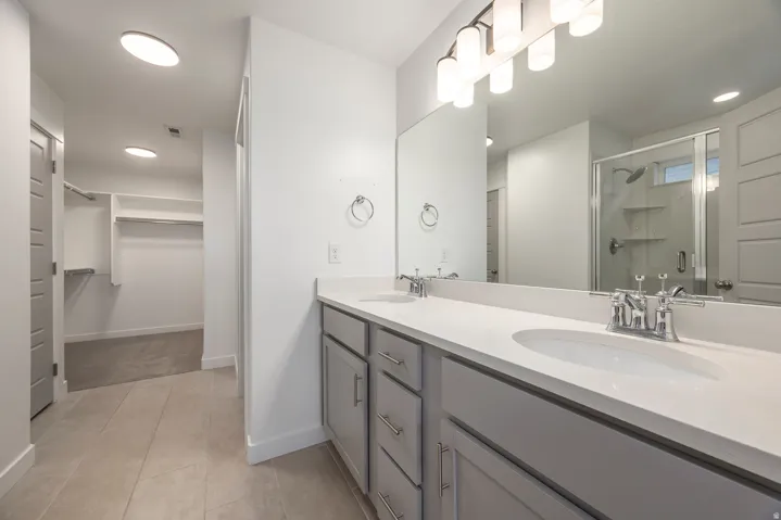 Dual vanity with undermount sinks, chrome fixtures, and light gray cabinetry