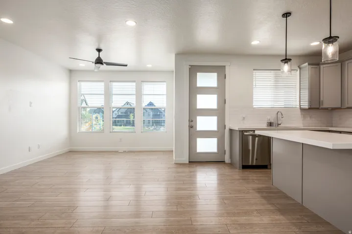 Open-concept living space with wood-finish flooring, a contemporary ceiling fan, and recessed lighting