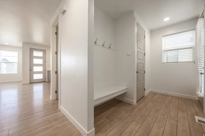 Wood-finish flooring throughout, with a built-in bench and coat hooks