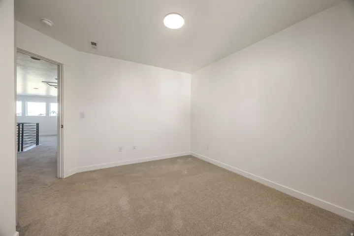 Bright, open room with neutral wall finishes, recessed ceiling lighting, and neutral carpet flooring