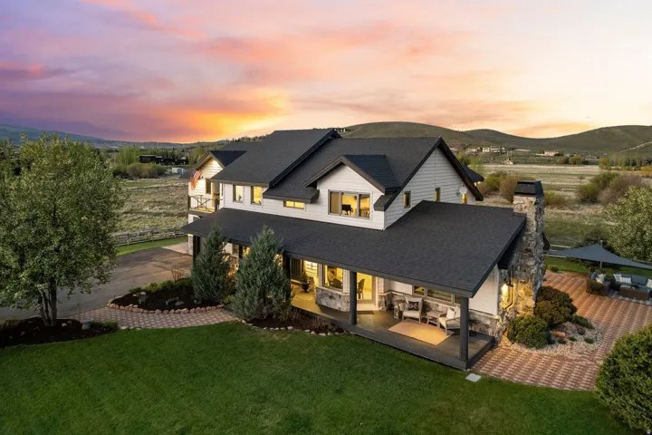 Two-story property with a dark shingle roof and light-colored siding