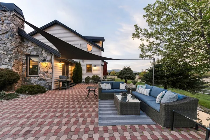 Expansive paver patio with a stone-clad exterior