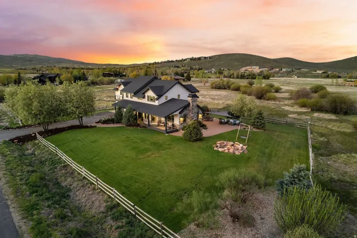 Expansive lawn with a perimeter fence and mature trees