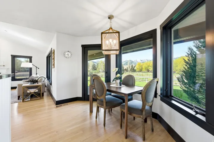 Hardwood flooring, crisp white walls, black window and door trim, and a contemporary ceiling fixture