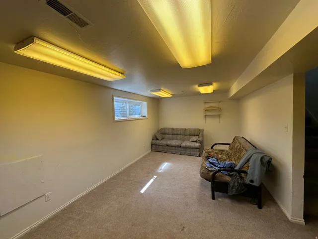 Carpeted room with recessed lighting and a single window