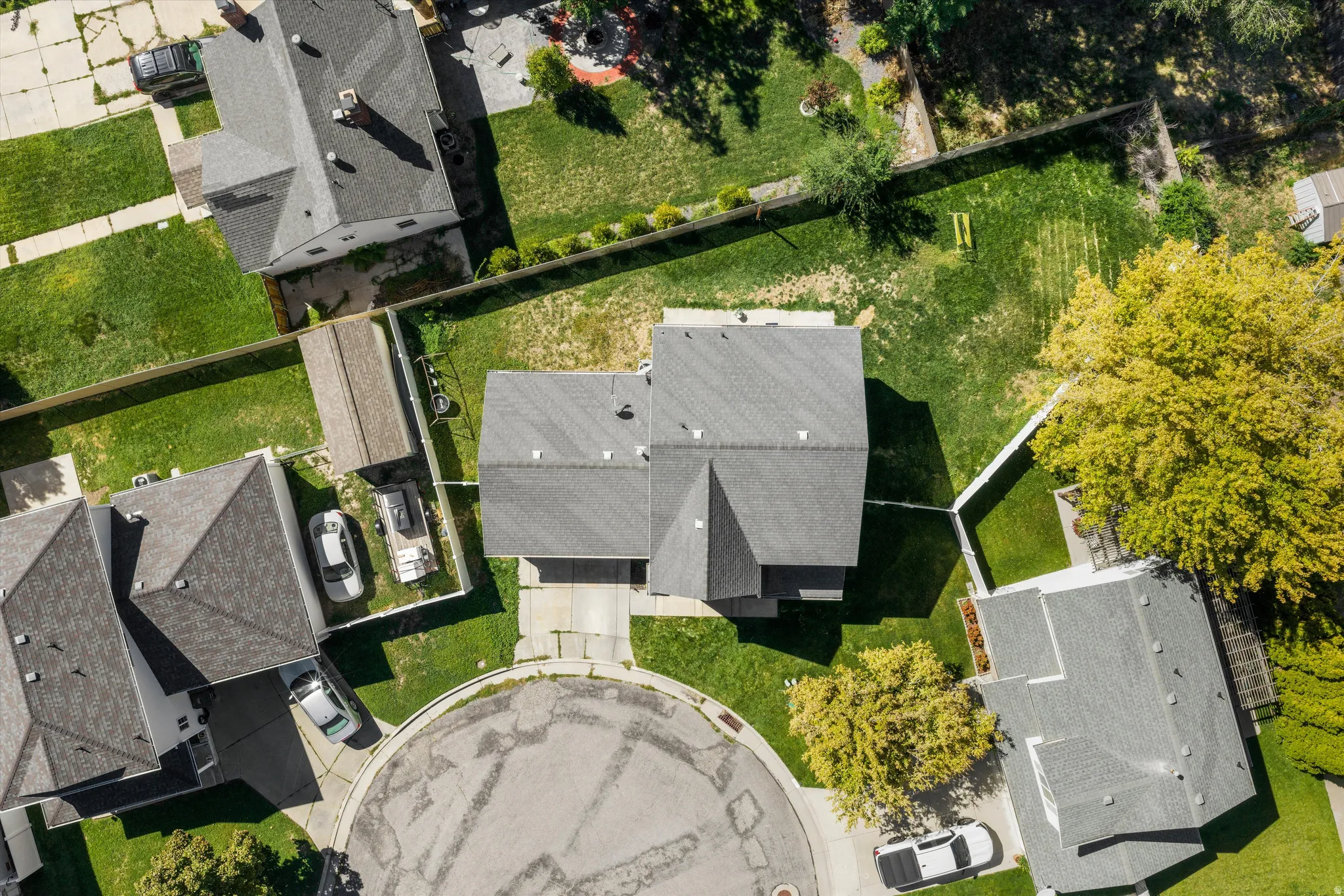 Property positioned on a cul-de-sac with a gray shingled roof and a paved driveway