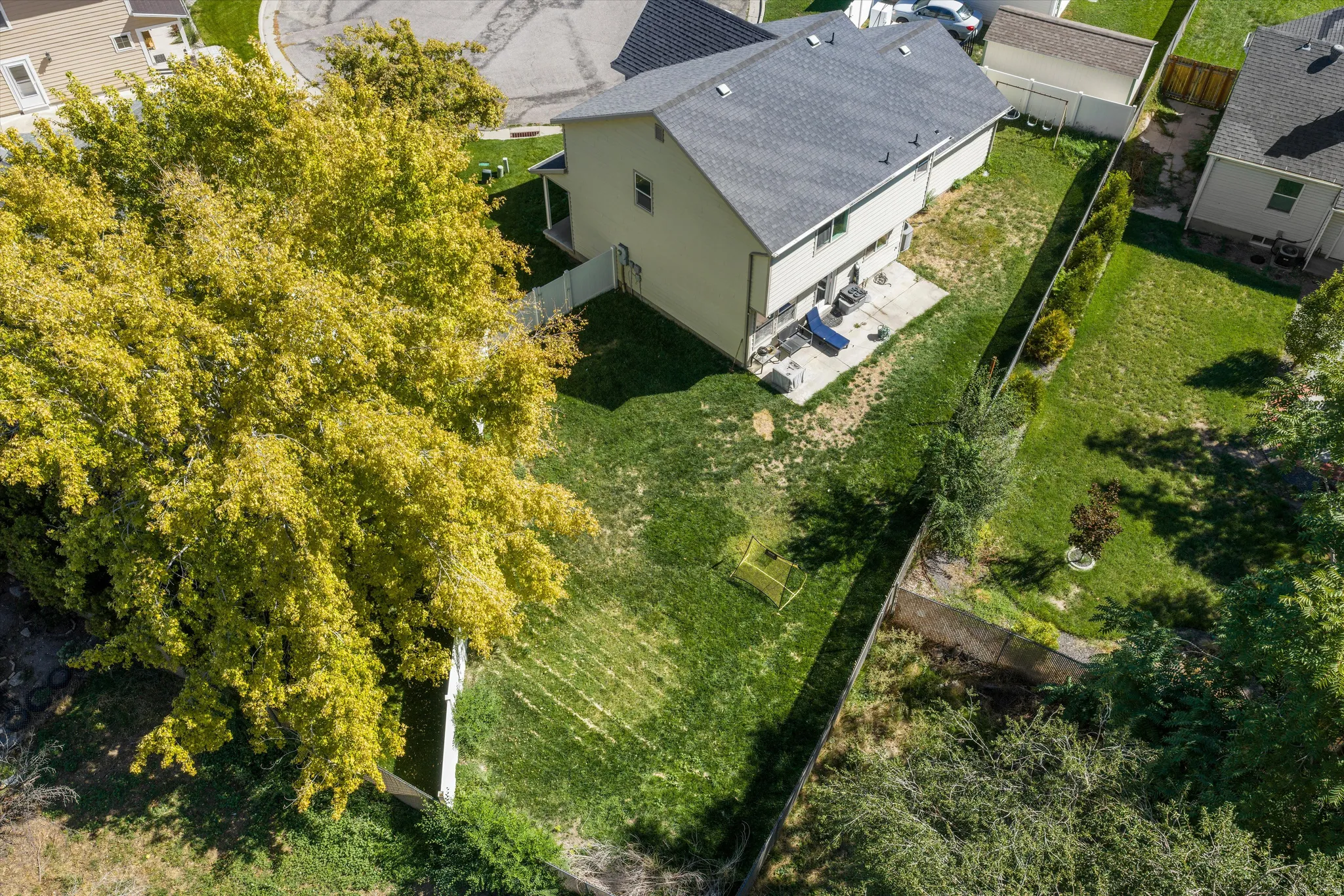 Expansive green lawn with mature trees and established landscaping