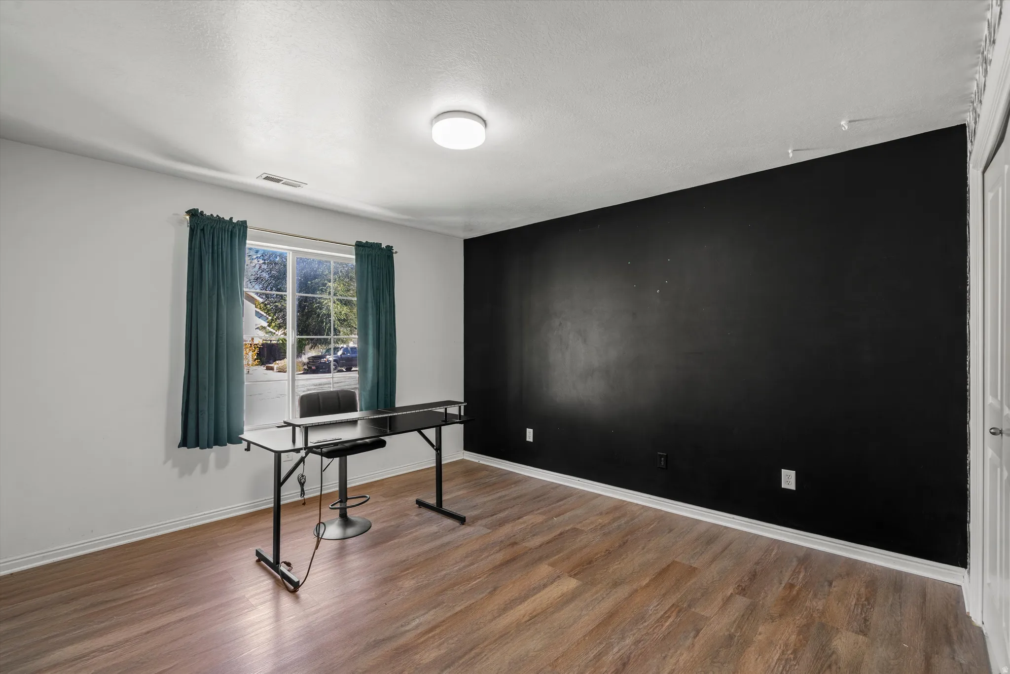 Wood-finish flooring, white walls, and a prominent accent wall
