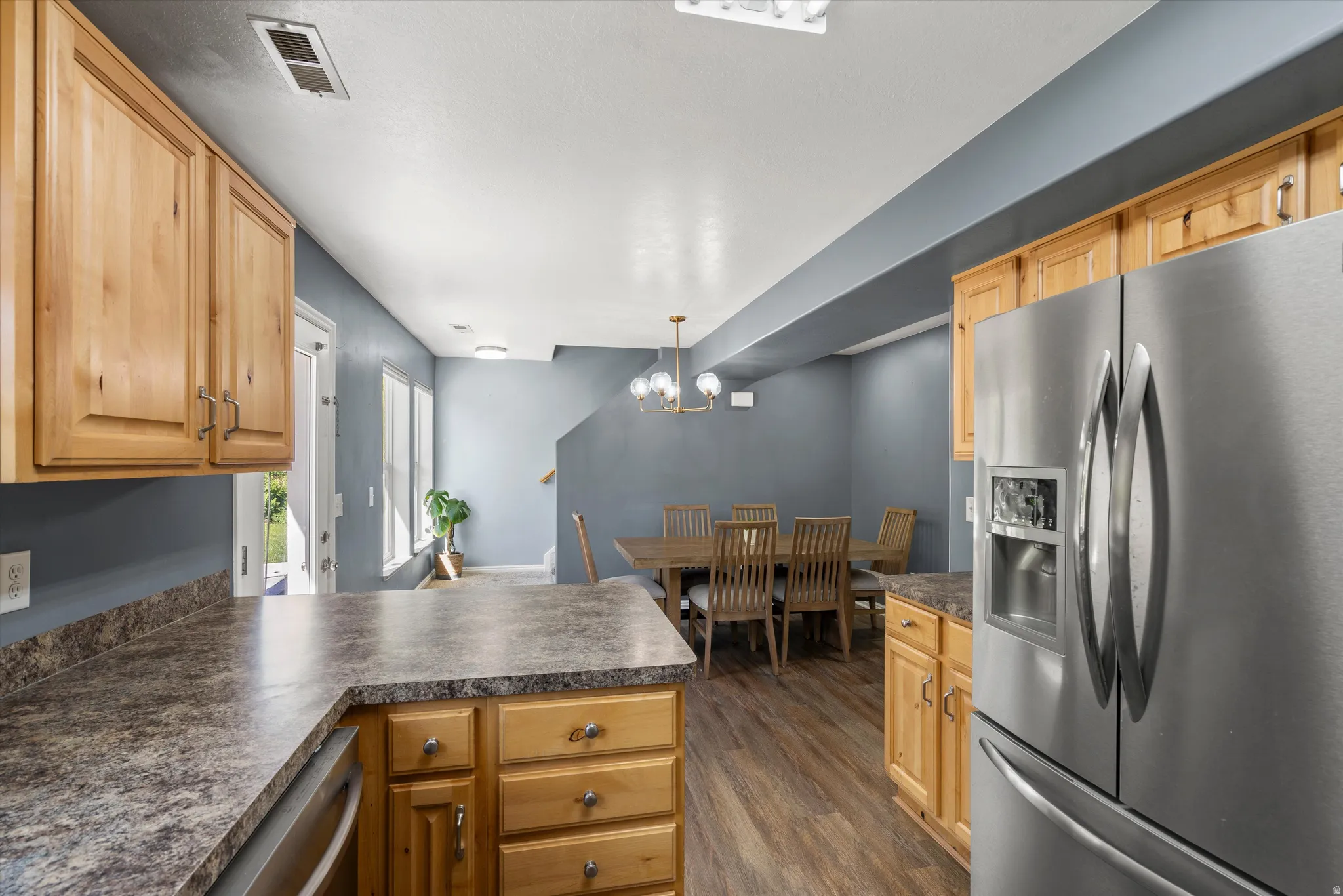 Kitchen featuring wood cabinetry, stainless steel refrigerator, and laminate countertops